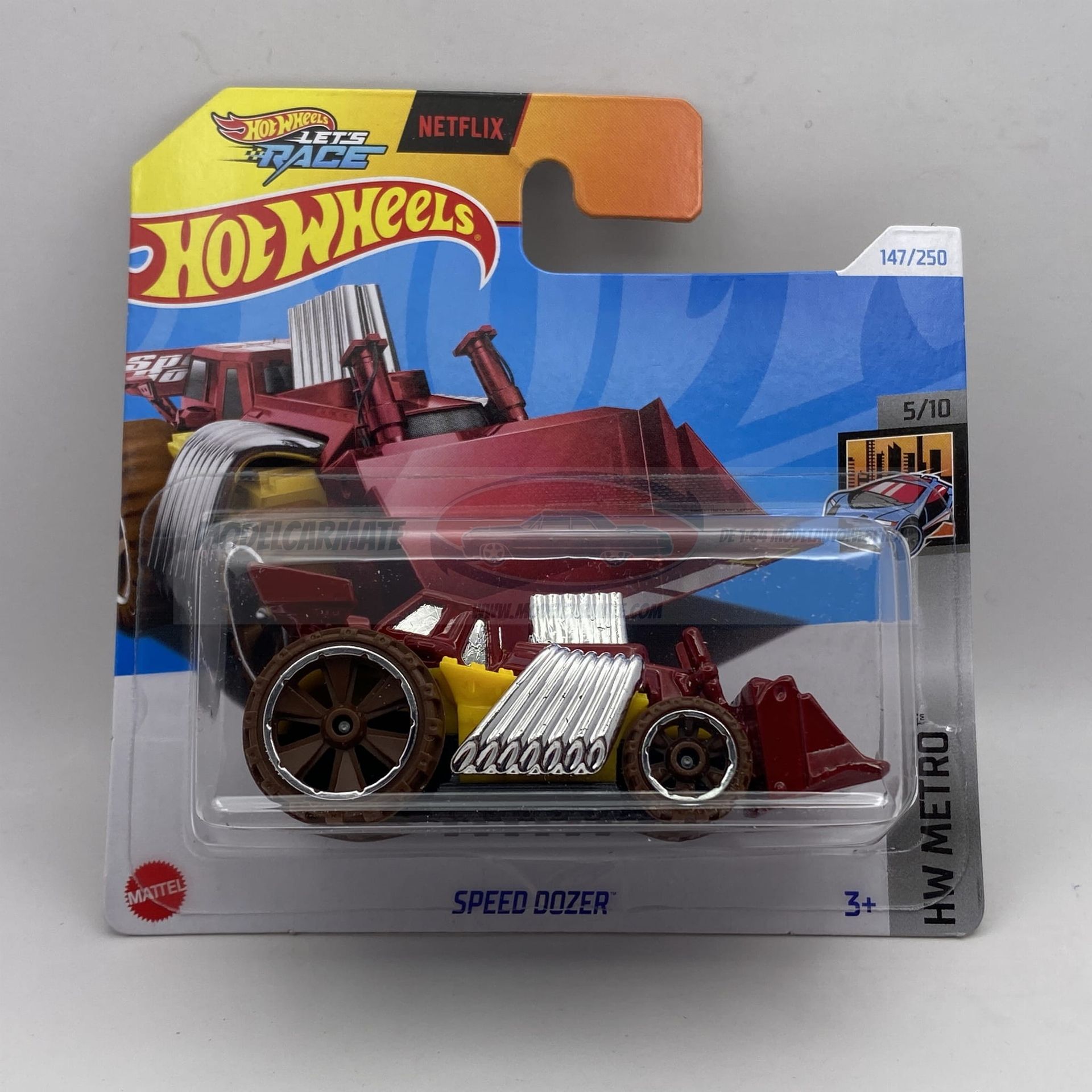 Hot Wheels Speed ​​Dozer speelgoedauto in verpakking, bruin en geel.