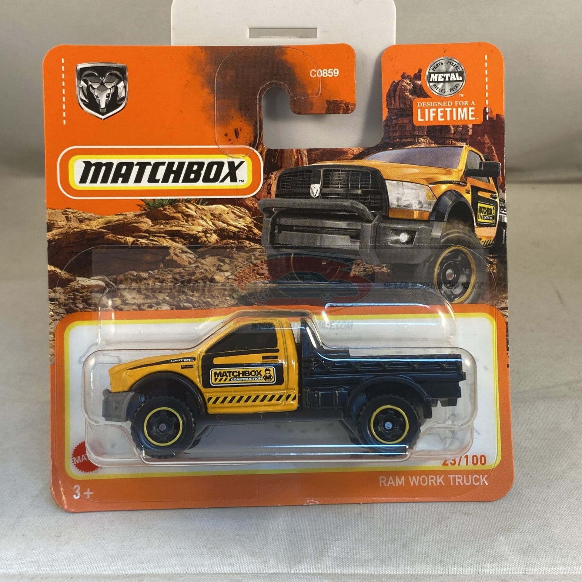 Een Matchbox-speelgoedauto van een gele en zwarte Ram-werktruck op de verpakking.