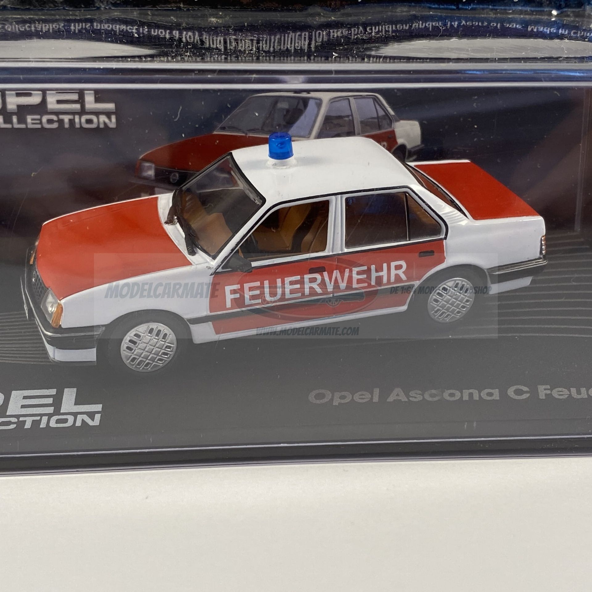 Opel Ascona C Feuerwehr modelauto in een vitrine; rood en wit met sirene.