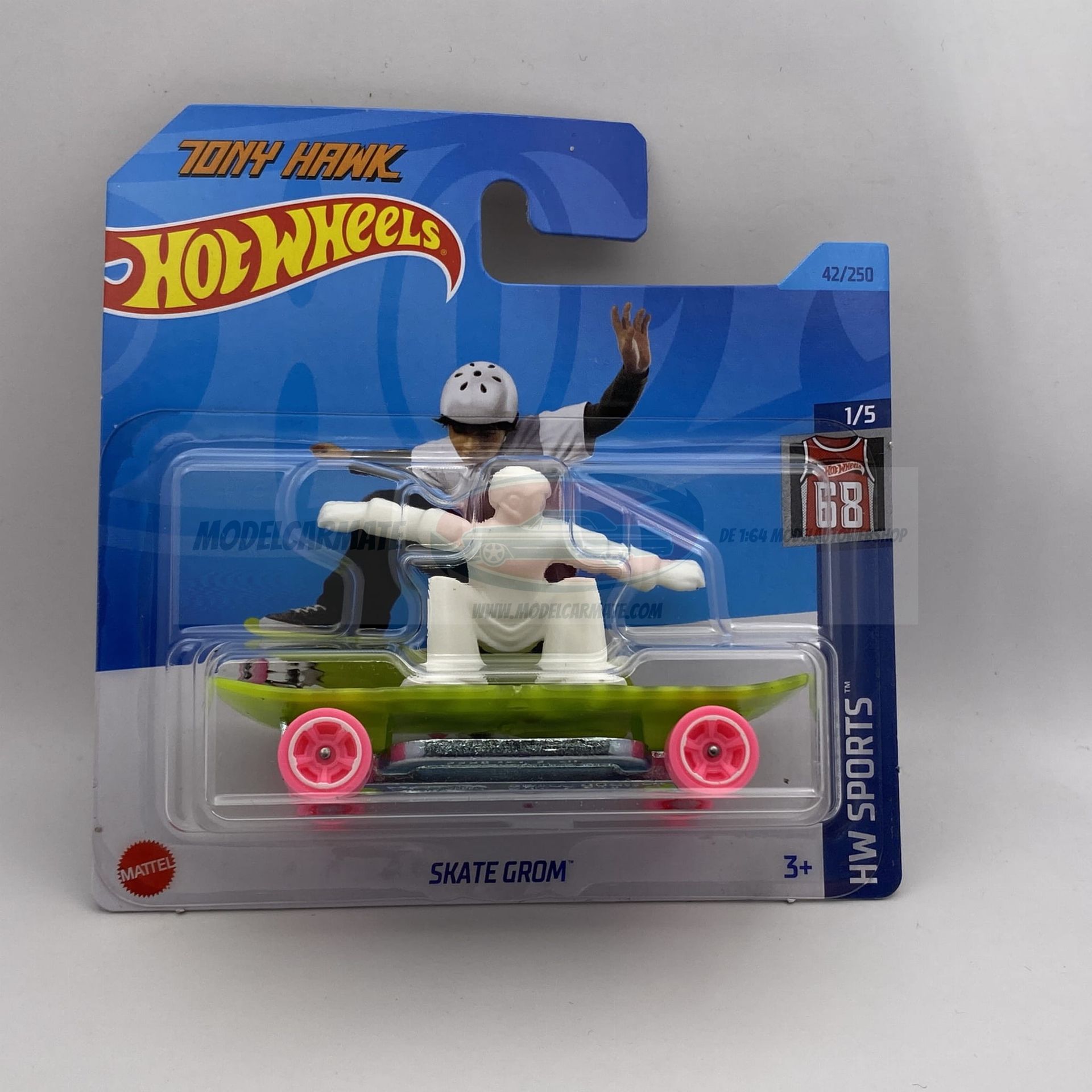 Hot Wheels-speelgoedfiguur van een skater op een groen skateboard, in een blauwe verpakking.