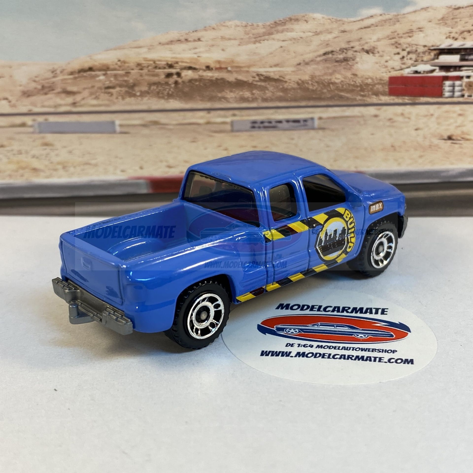 Blauwe speelgoedpick-uptruck met stadslogo op een witte ondergrond, wazige achtergrond.