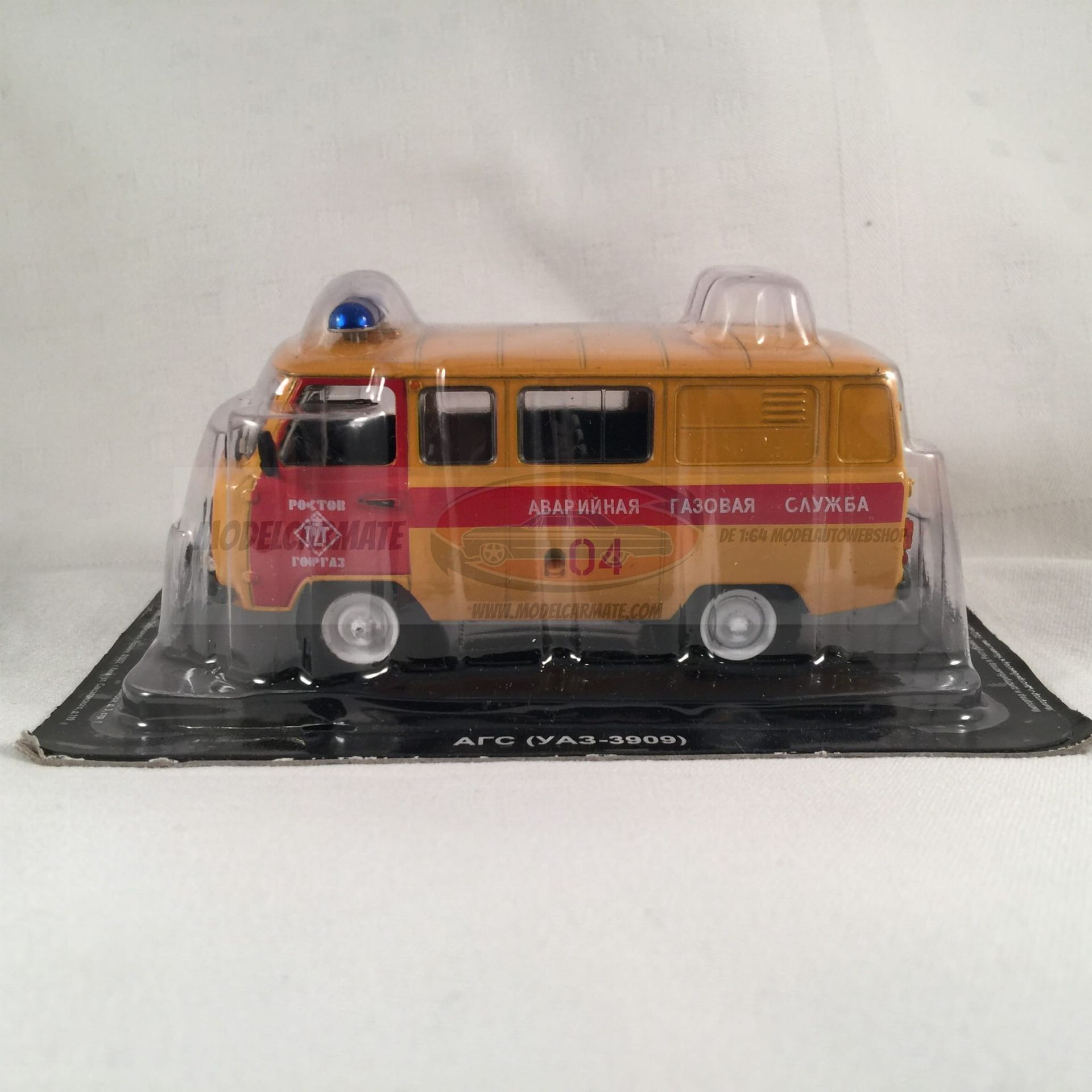 Model van een gele en rode brandweerwagen in een plastic verpakking.