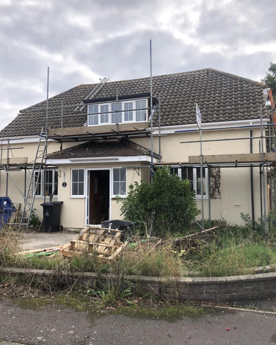 A house with scaffolding on the roof is being remodeled