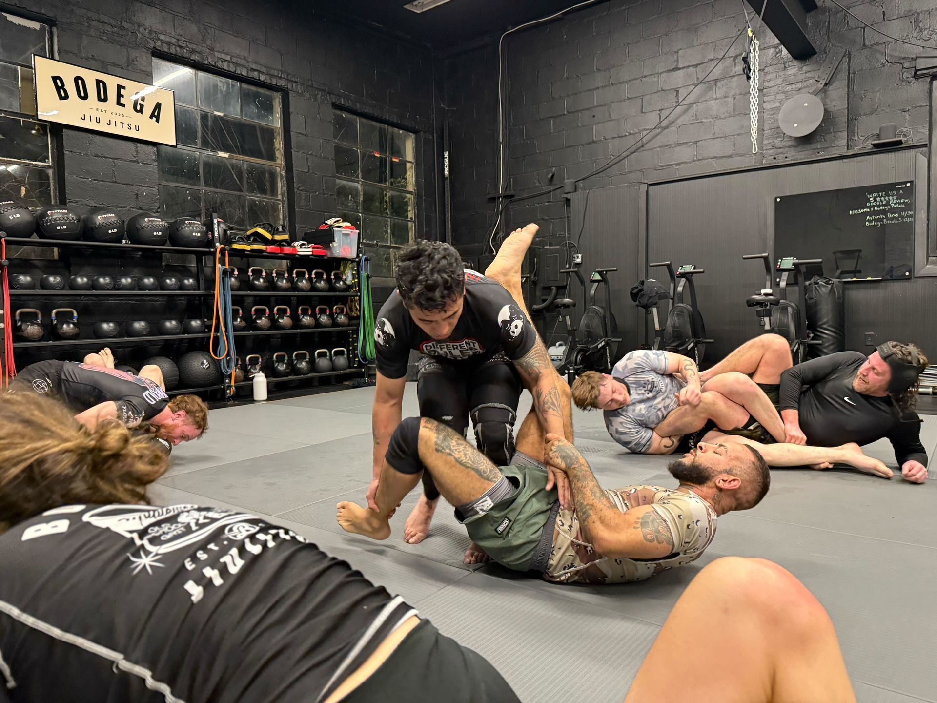 Adults practicing grappling technique at Bodega Jiu-Jitsu in Maplewood, NJ, building calm confidence together.