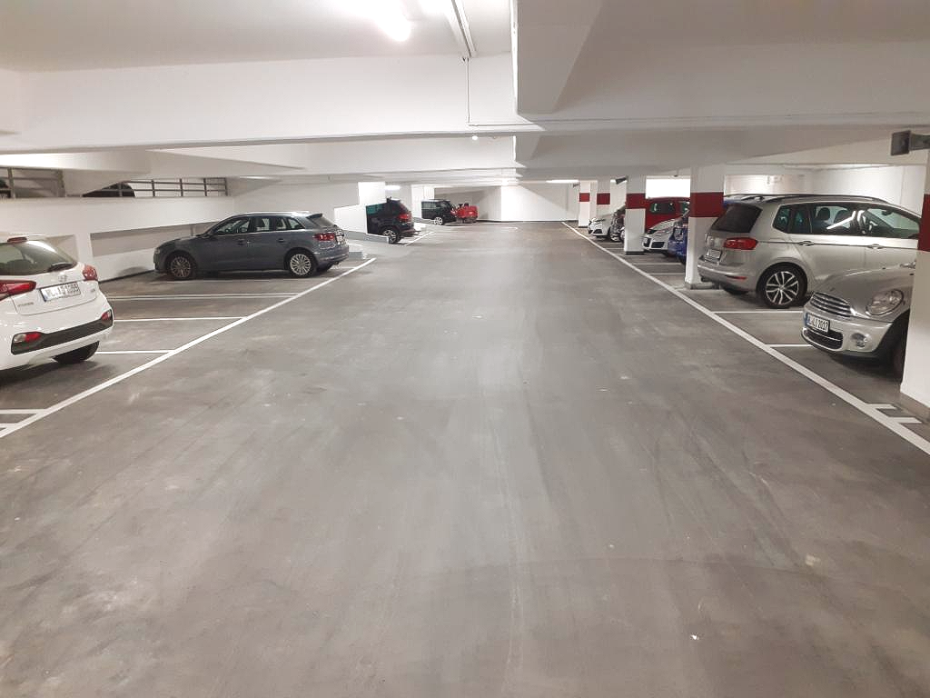 Tiefgarage mit Autos, die beidseitig einer breiten Mittelspur parken