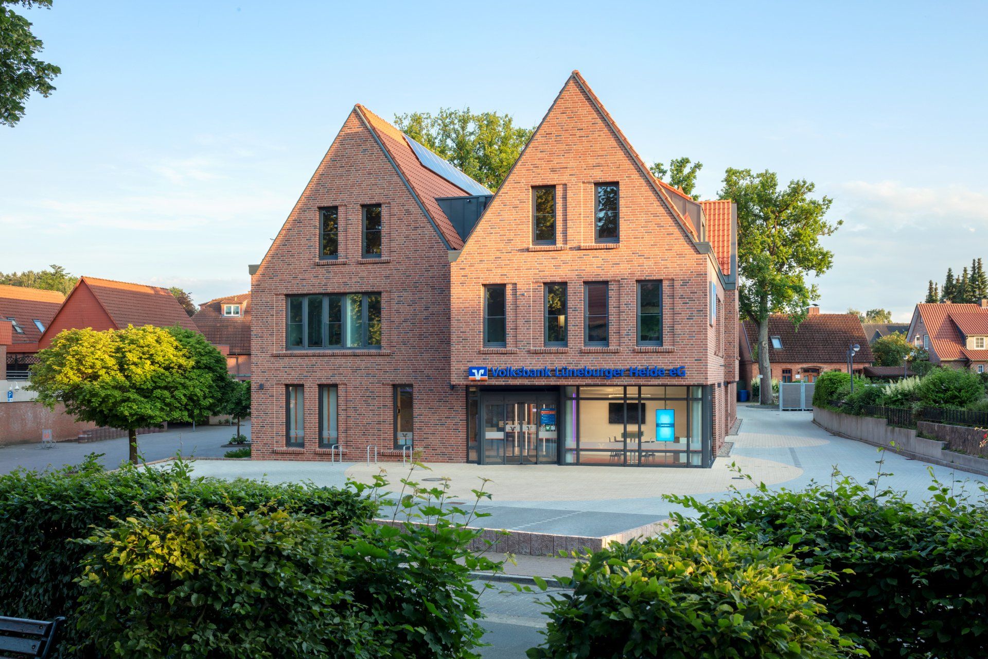 Backstein-Wohnhaus mit steilen Giebeldächern, großen Fenstern und einem kleinen Vorplatz