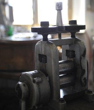 A metal rolling mill machine with gears and rollers.