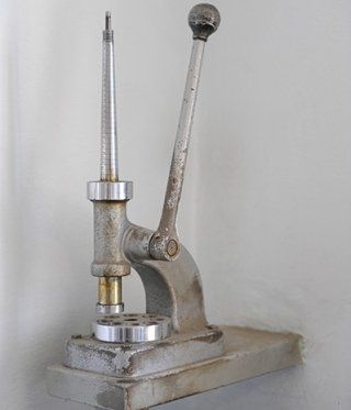 Metal ring sizing tool with lever, adjustable mandrel, and base.