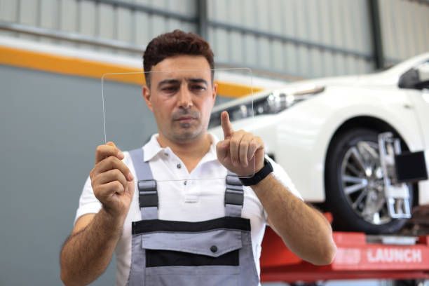 Auto glass specialist inspects pane.