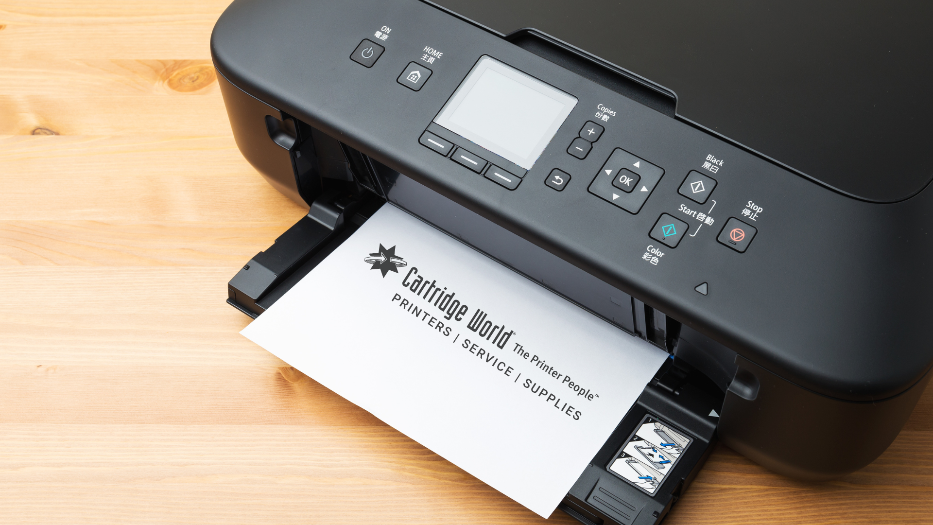 Black printer printing a document with the Cartridge World logo on a wooden surface.