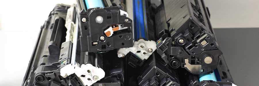 Close-up of a disassembled machine's internal components, featuring black plastic parts, white accents, and a blue tube.