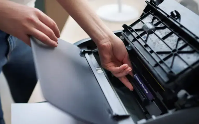 Person removing or installing a toner cartridge in a printer.