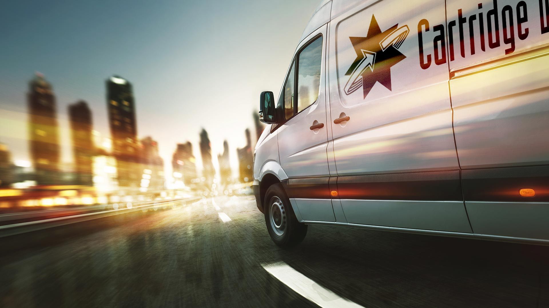 White delivery van with logo, driving on a road toward city skyline.