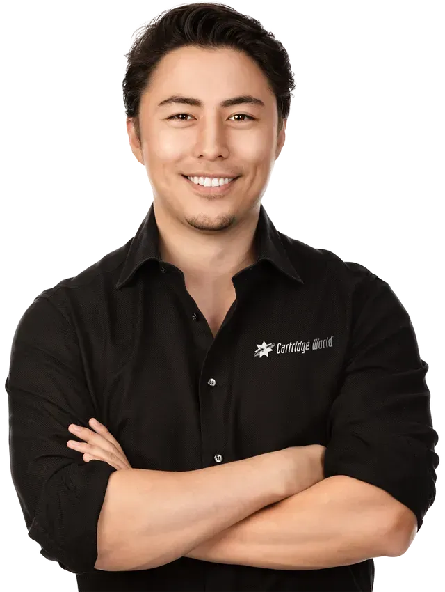 Man with arms crossed, smiling, wearing a black shirt with