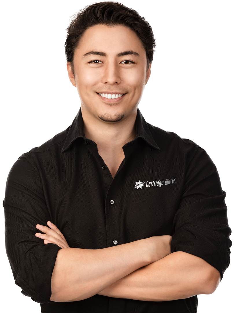 Man with crossed arms smiling, wearing a black collared shirt.