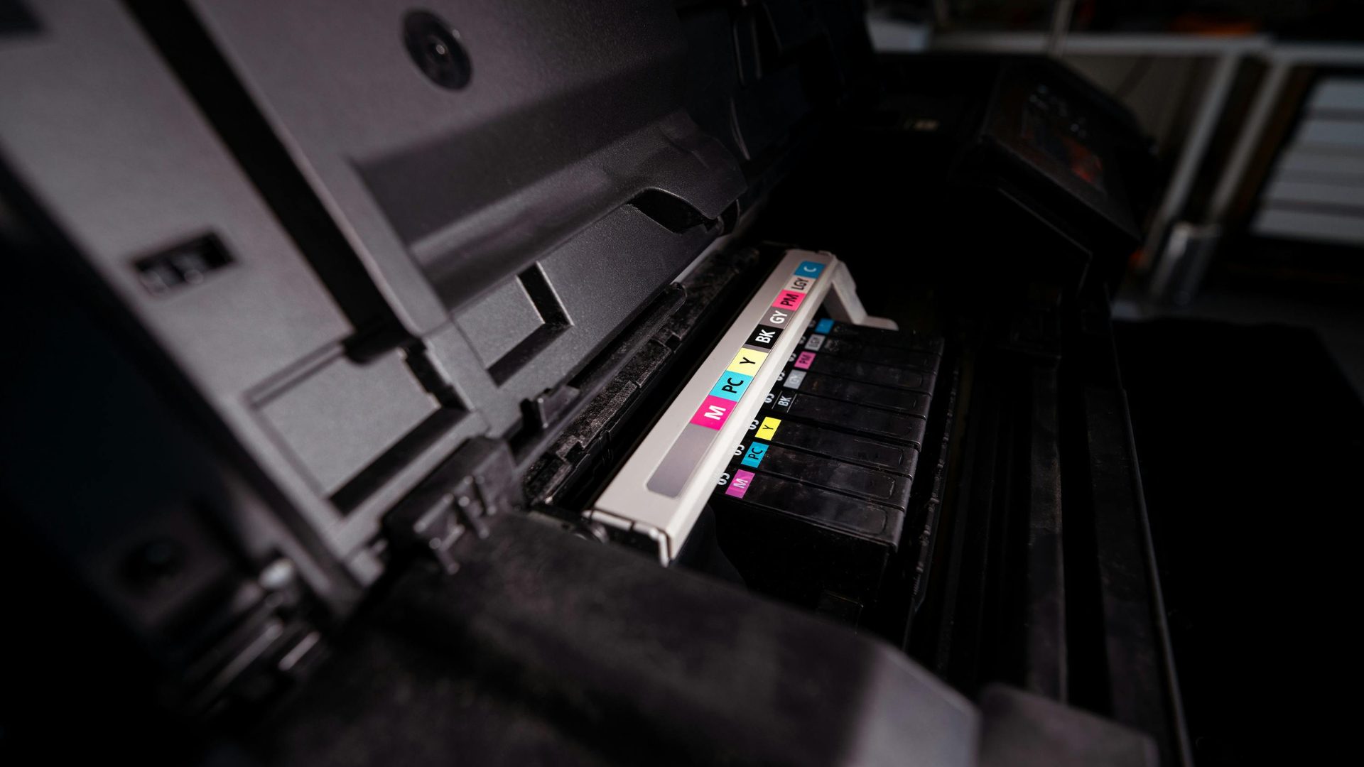 Printer ink cartridges in a printer, displaying colored ink levels.