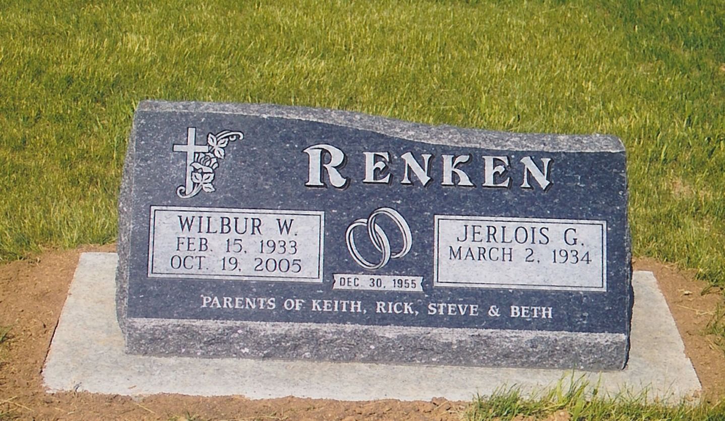 Renken family gravestone on a grassy lawn with two name plaques and a cross emblem