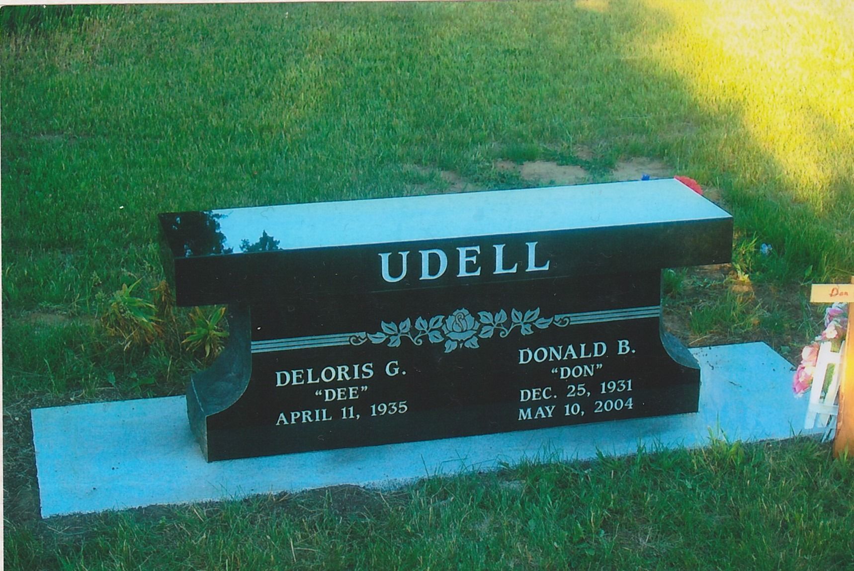 UDELL cemetery headstone with blue base on a grassy lawn