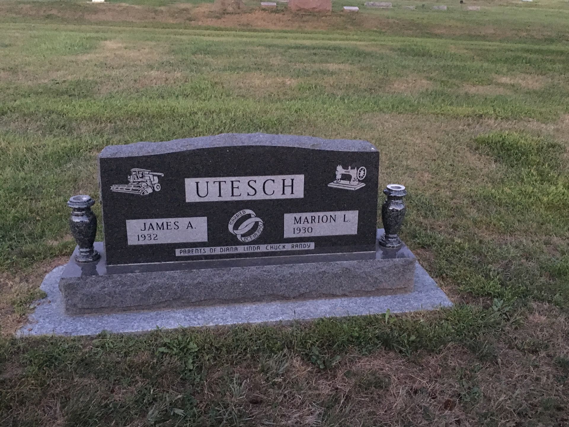 Black Utesch family gravestone with engraved plaque on a grassy cemetery plot
