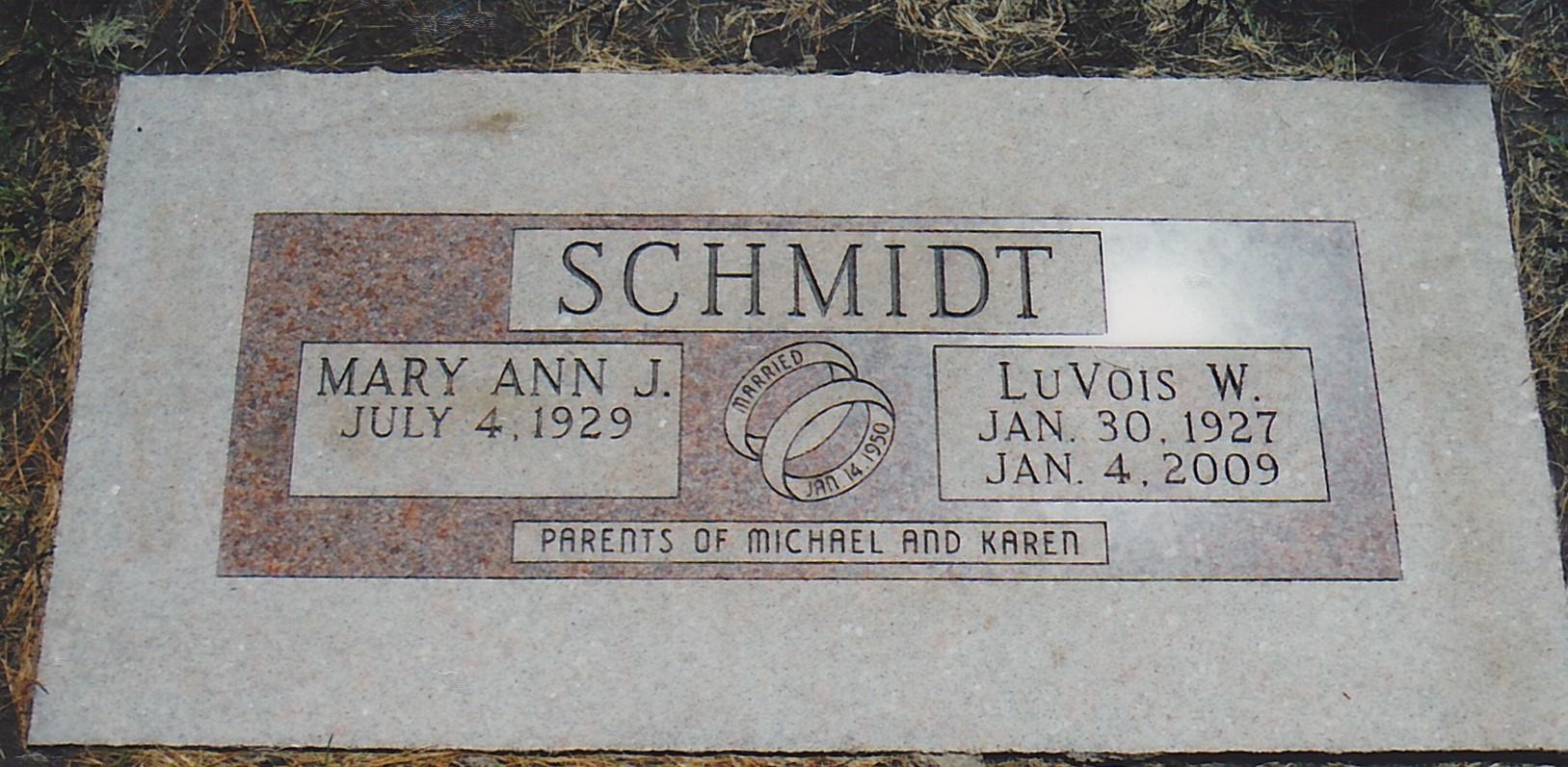 Gravestone for Schmidt family with Mary Ann and Leonard S. plaques on a white stone marker.
