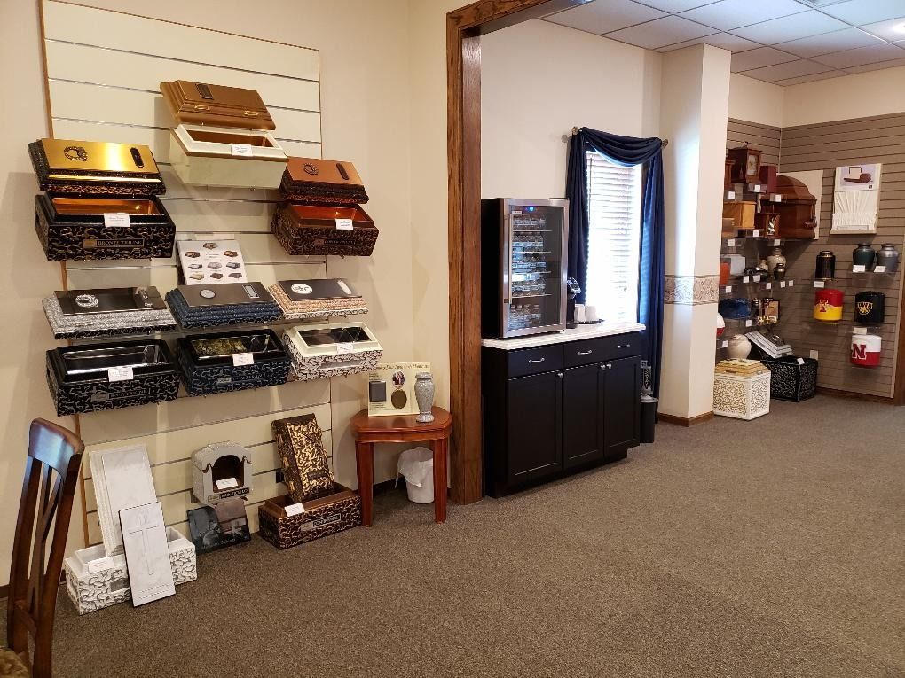 Retail showroom with wall-mounted display shelves and a black cabinet in a carpeted room