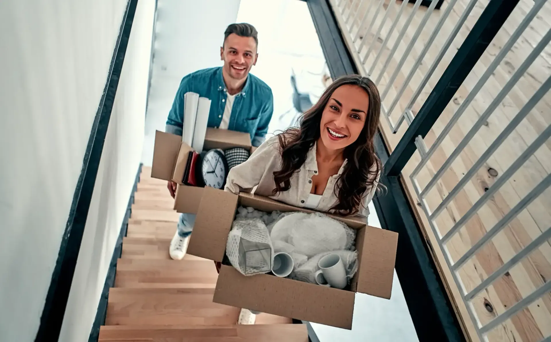 Couple carrying boxes upstairs