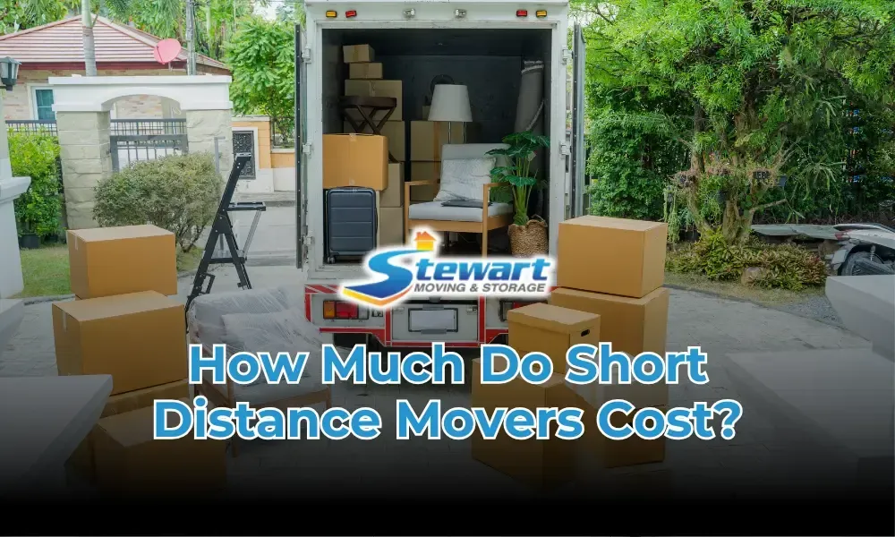 A truck filled with boxes is parked in front of a house.