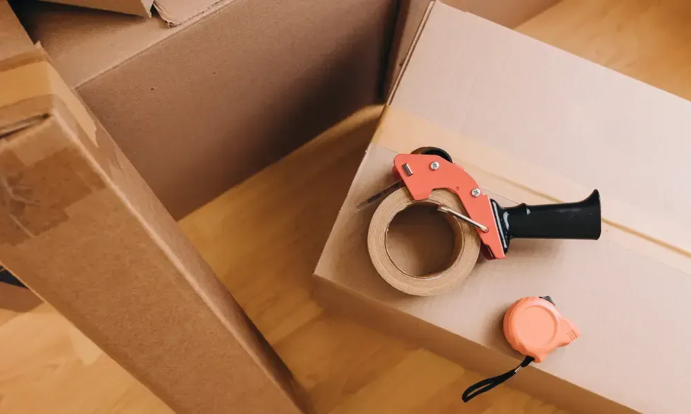 A tape dispenser is sitting on top of a cardboard box.