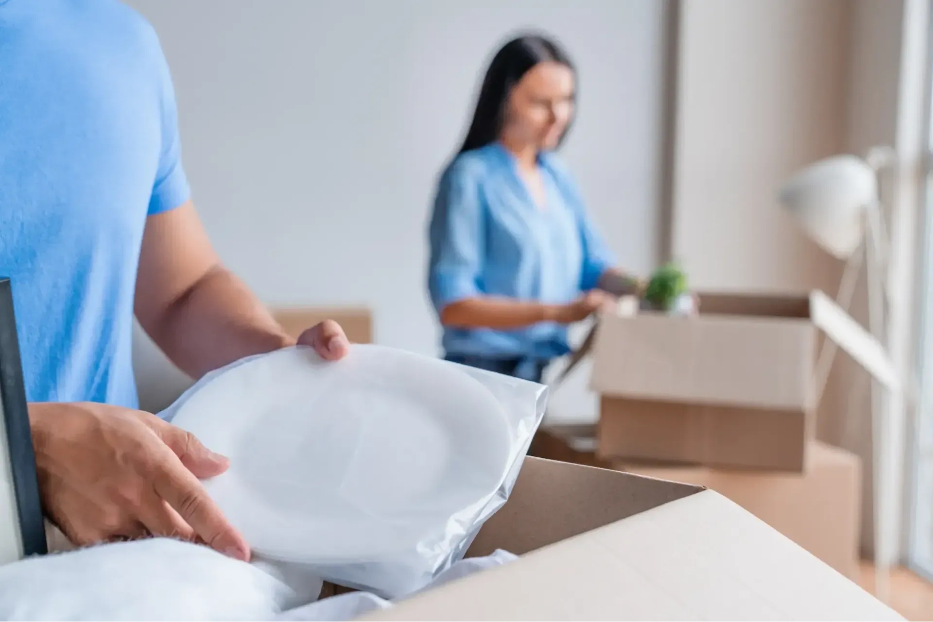 Family packing up plates into moving boxes
