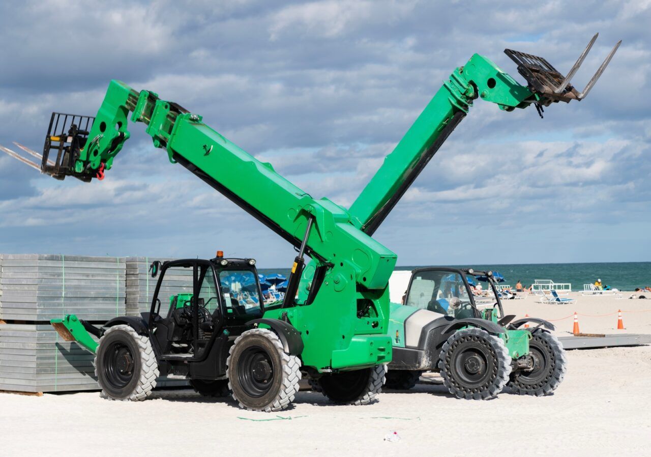 A Green Forklift is Lifting a Bird on a Beach — FNQ Hot Water In Mareeba, QLD