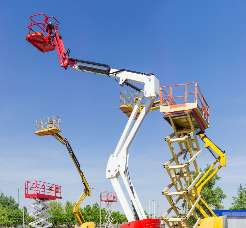 Three Scissor Lifts Are Parked in a Parking Lot Against a Blue Sky — FNQ Hot Water In Mareeba, QLD