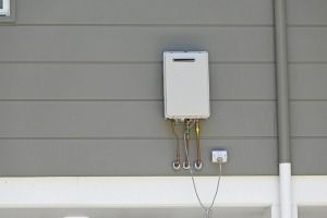 A White Water Heater is Mounted on the Side of a Building — FNQ Hot Water In Port Douglas, QLD