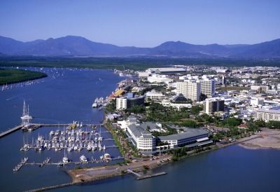 An Aerial View of a City Next to a Body of Water With Mountains in the Background — FNQ Hot Water In Cairns, QLD