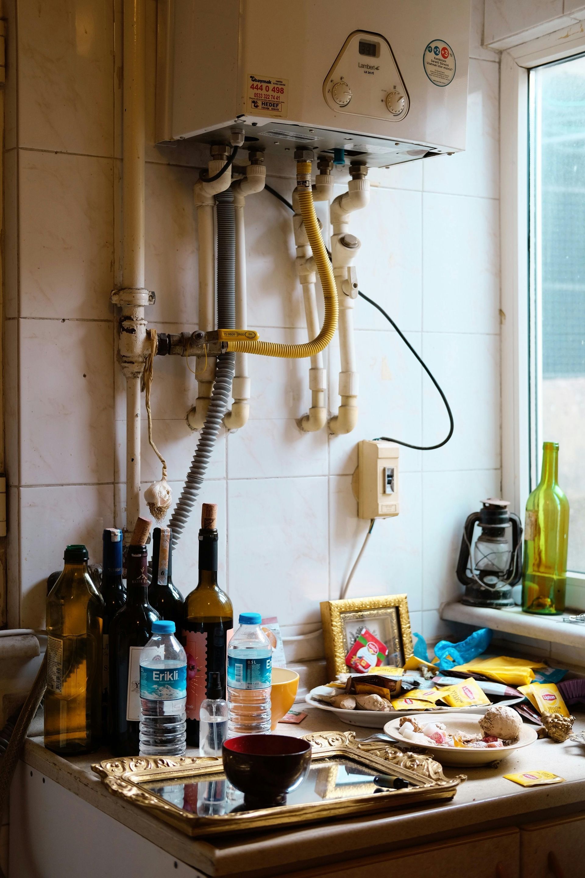 A Kitchen Counter With Bottles of Wine and a Heater on the Wall — FNQ Hot Water In Atherton, QLD