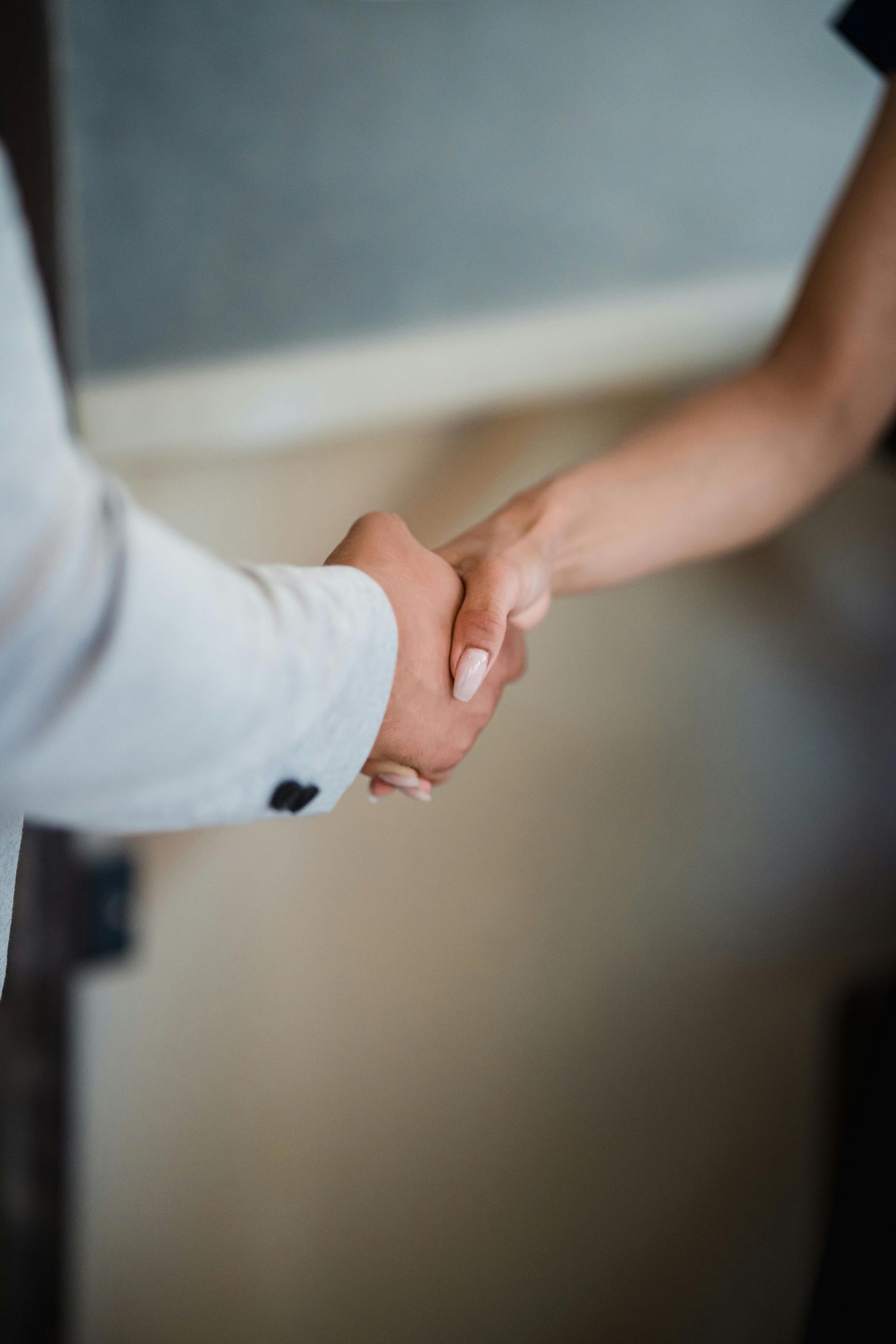 A Man And A Woman Are Shaking Hands In A Room — FNQ Hot Water In Mareeba, QLD