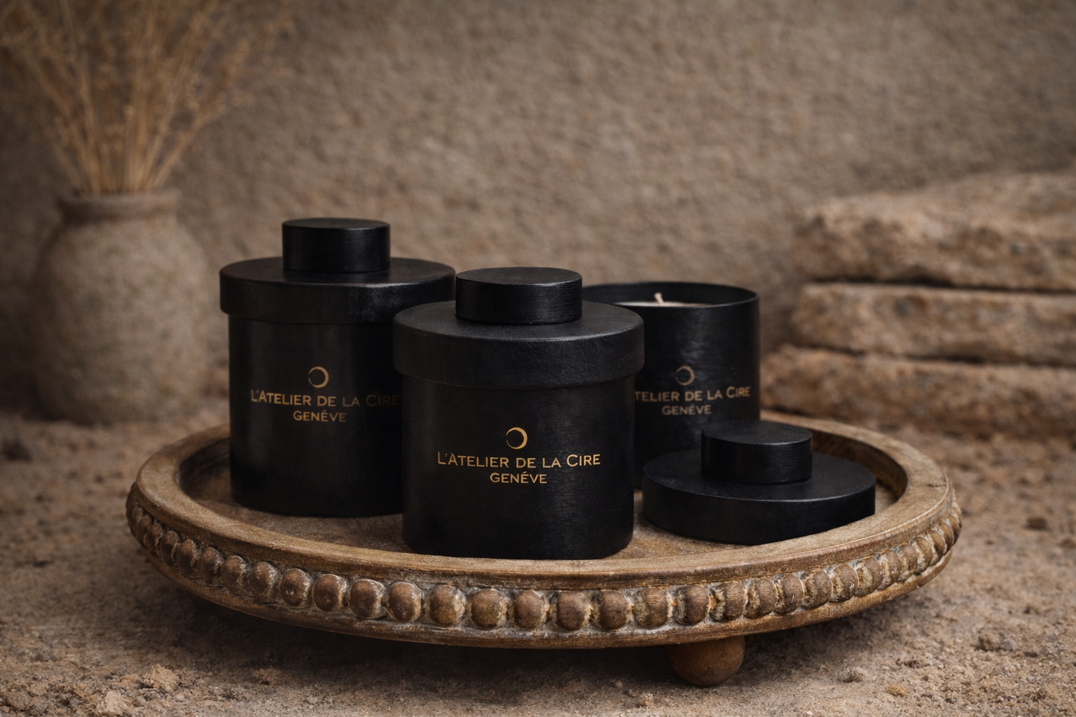 Des pots cosmétiques noirs sur un plateau décoratif dans un cadre rustique et chaleureux