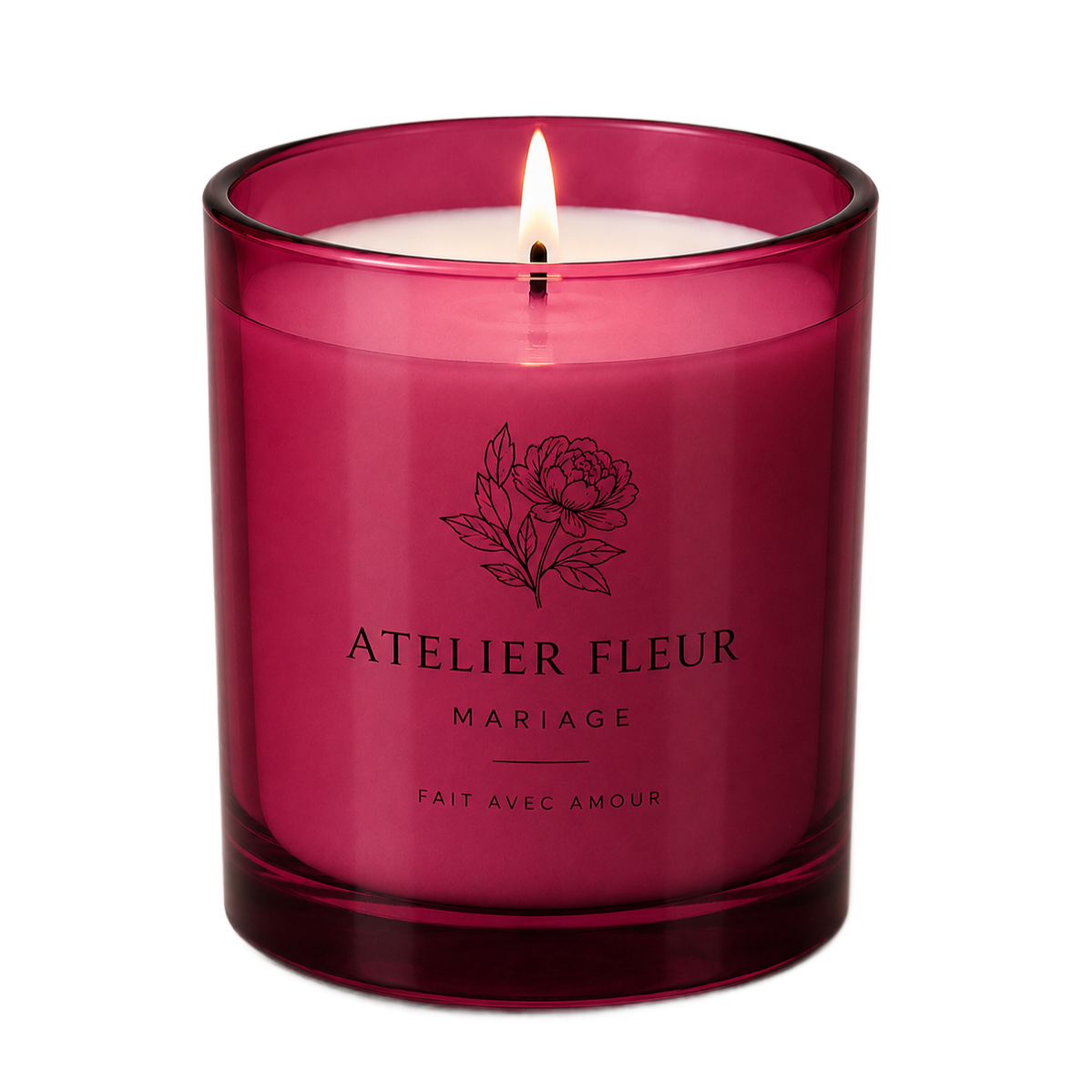 Bougie en verre magenta avec mèche allumée et étiquette Atelier Fleu