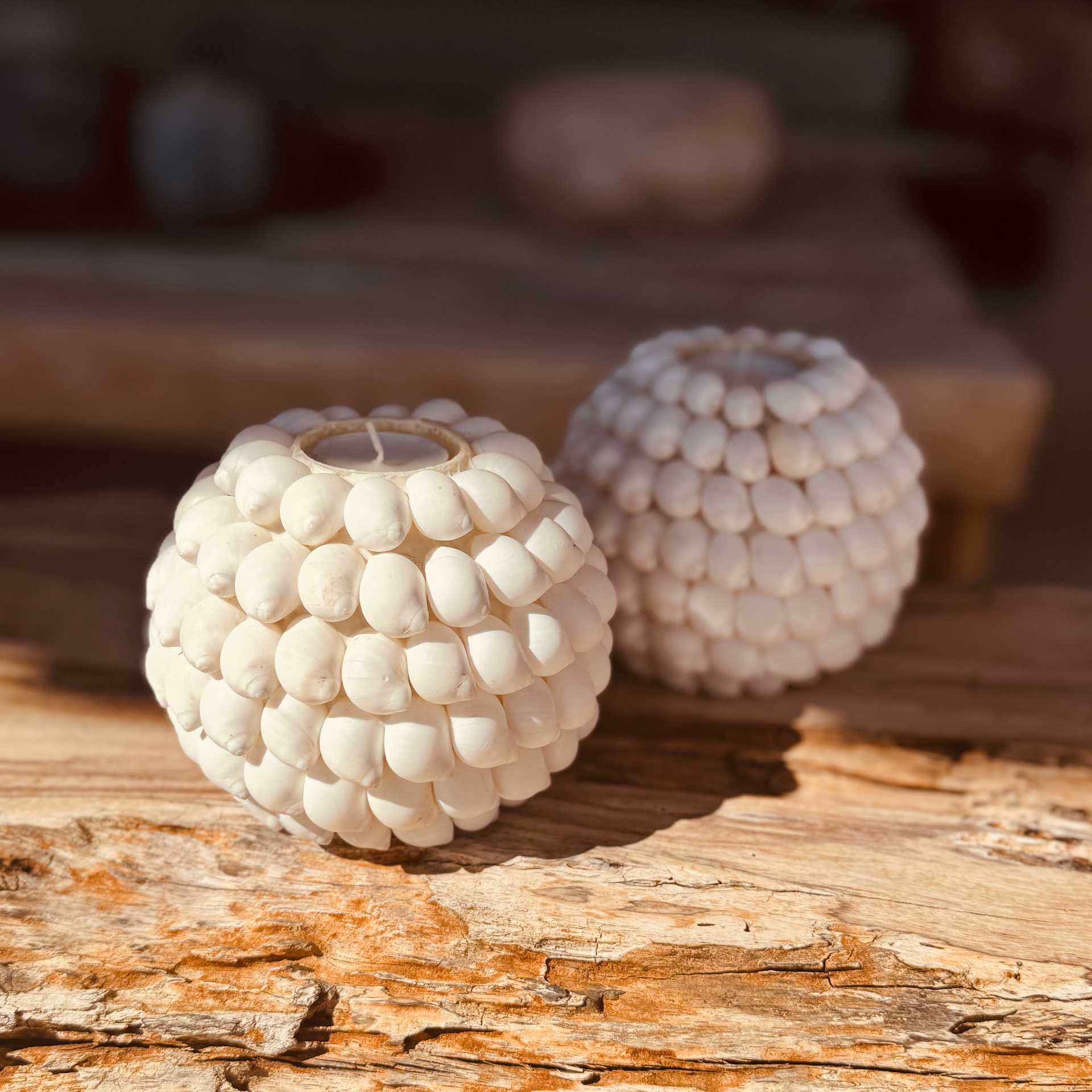 Sphère blanche perlée reposant sur une surface rocheuse texturée sous la chaude lumière du soleil
