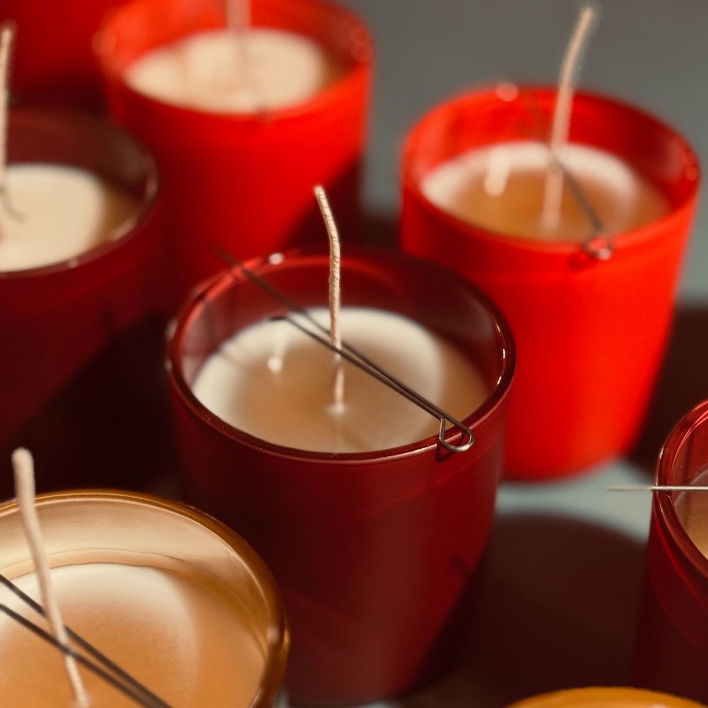 Bougeoirs rouges et dorés avec cire et mèches blanches.