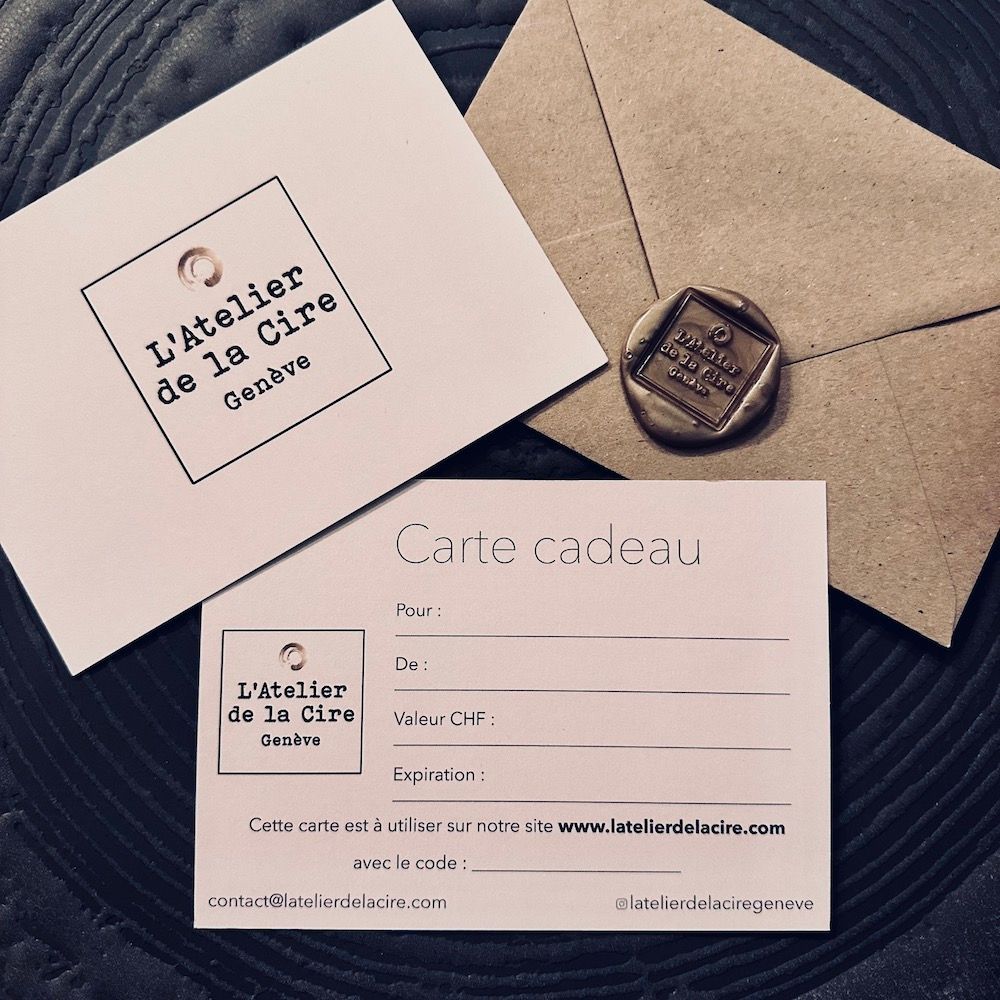 Carte cadeau et papeterie de L'atelier de la cire, disposées sur une table beige avec un sceau de cire.