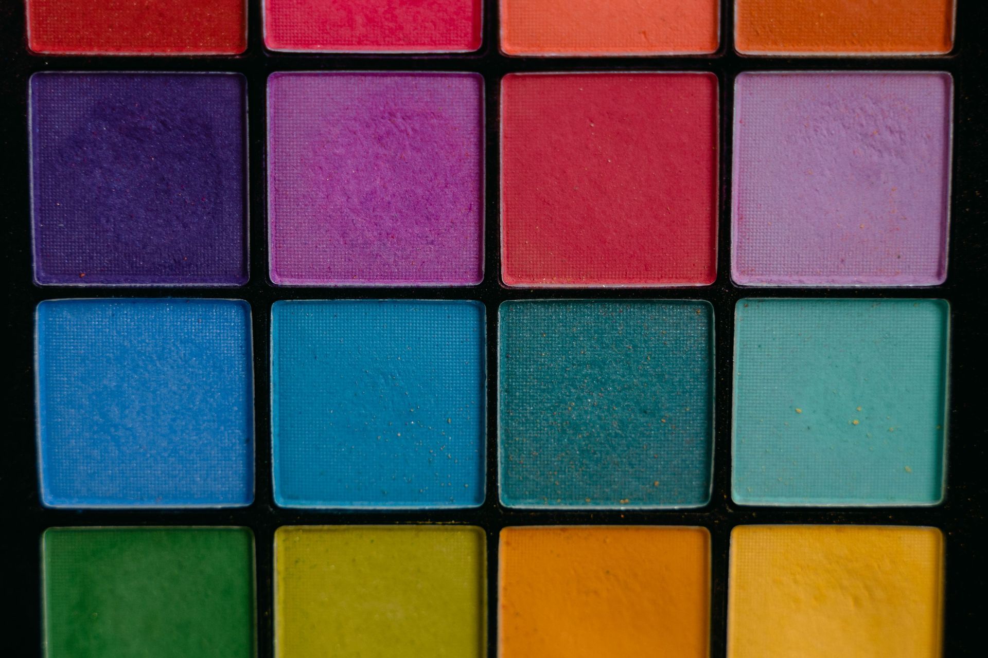 Des carreaux carrés colorés disposés en grille, composés de blocs rouges, violets, bleus, verts, turquoise et jaunes.