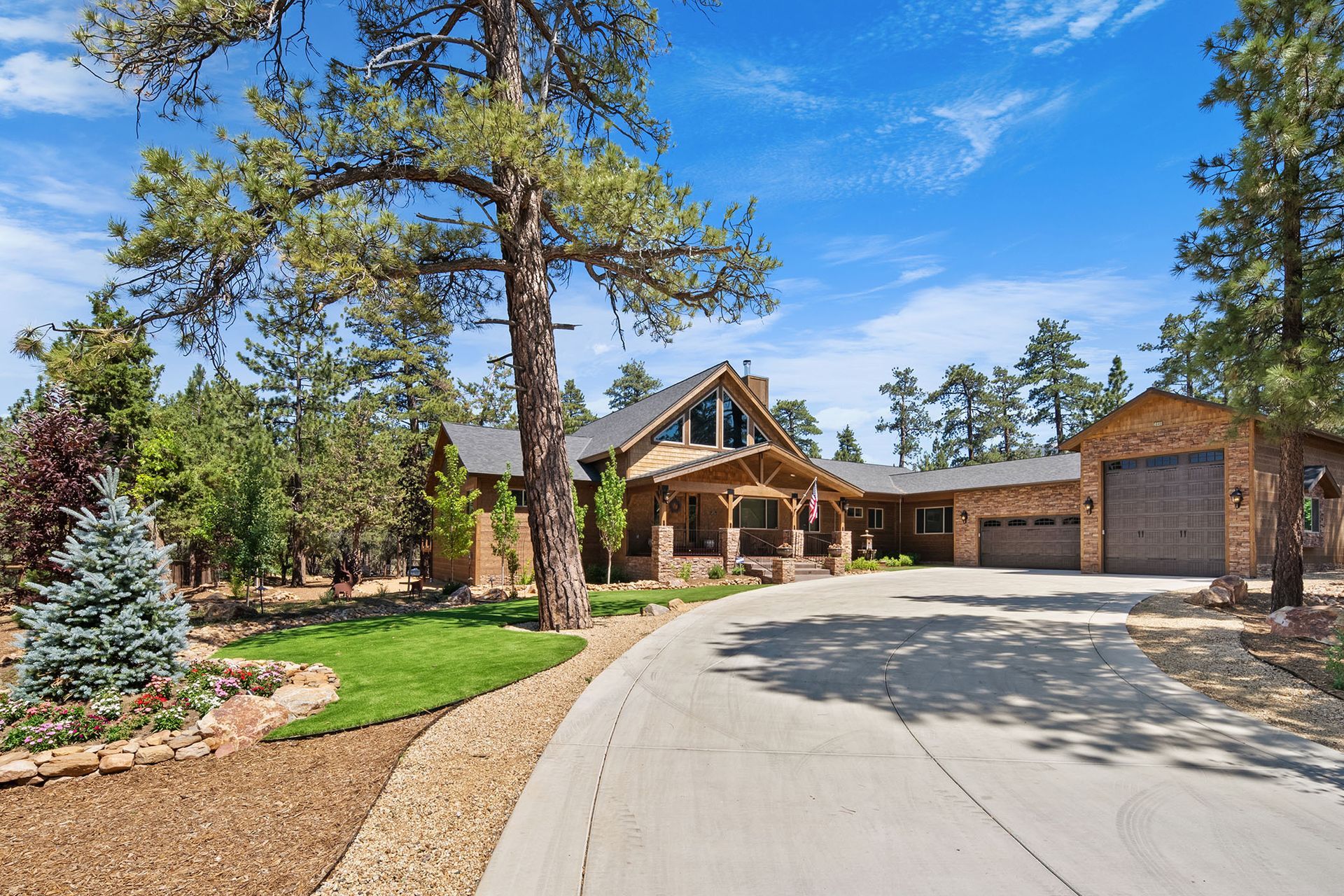 A large house with a driveway leading to it is surrounded by trees.