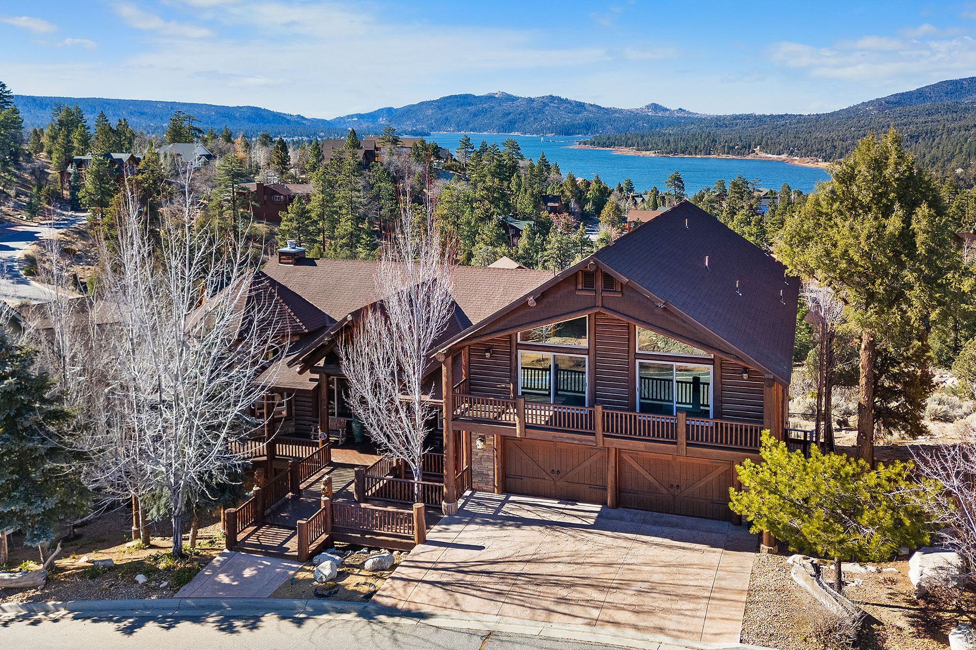An aerial view of a large house with a lake in the background.