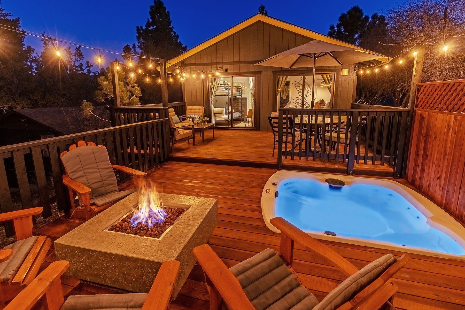 A house with a hot tub and a fire pit on the deck.