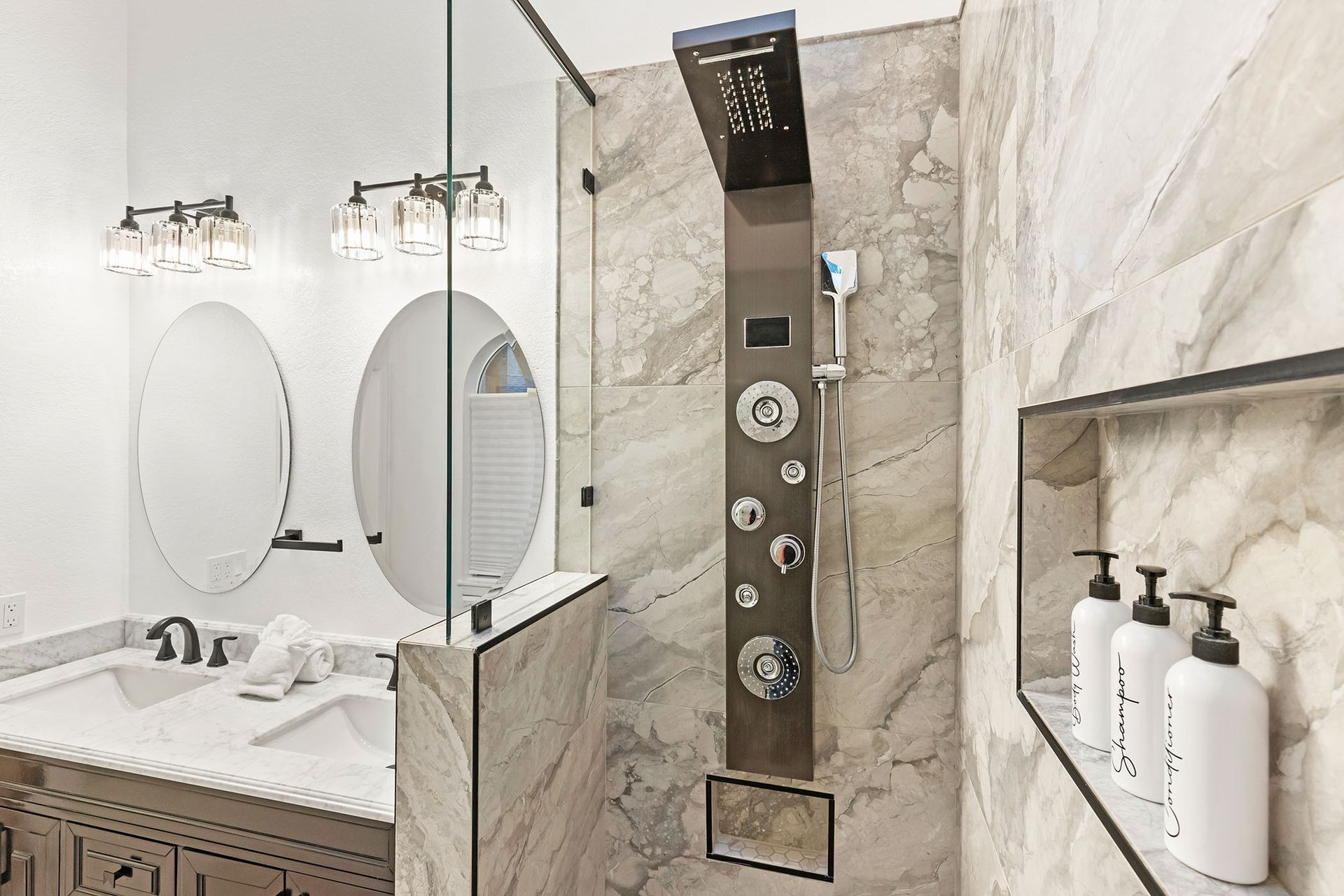 A bathroom with a shower , sink and mirror.