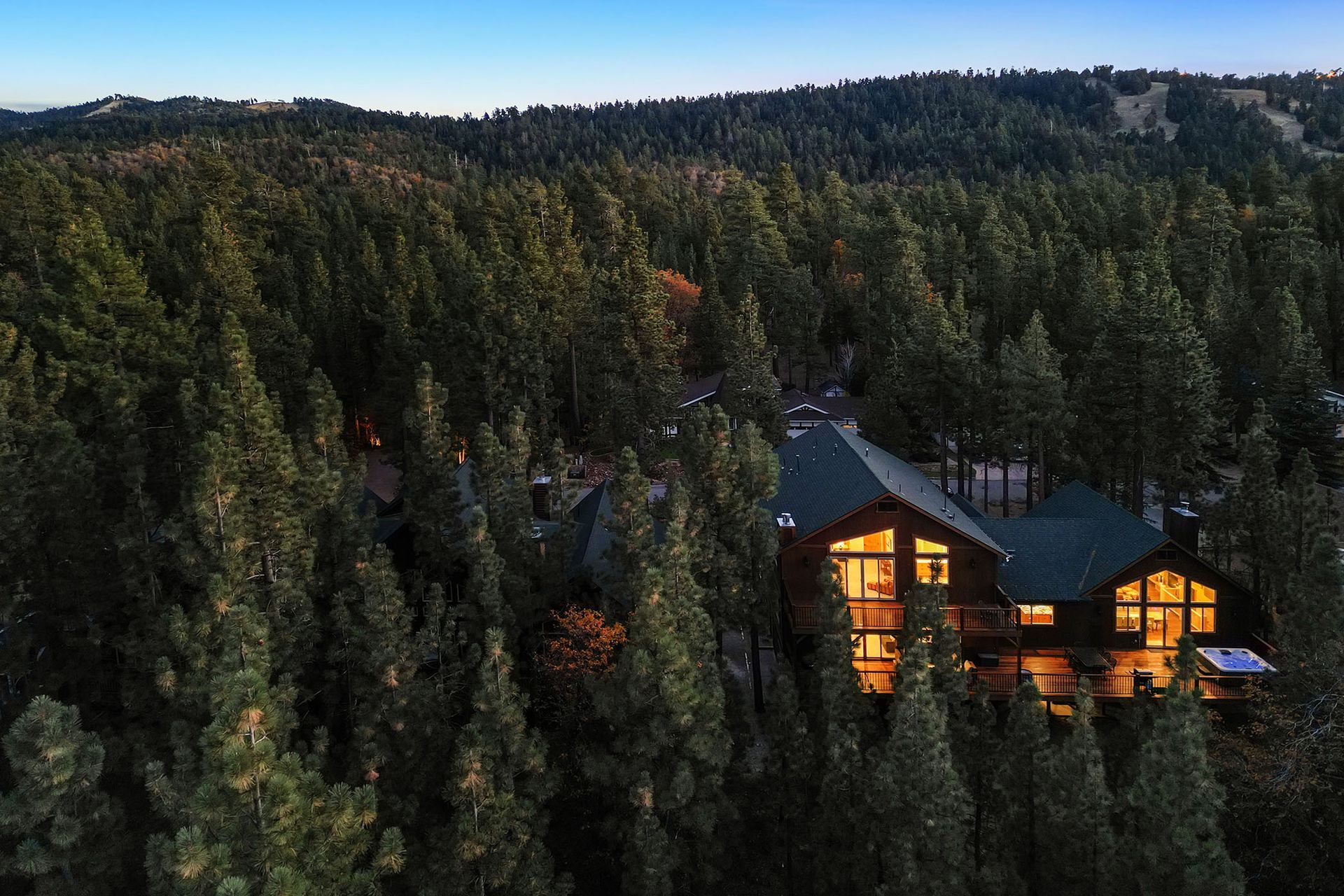 An aerial view of a house in the middle of a forest.