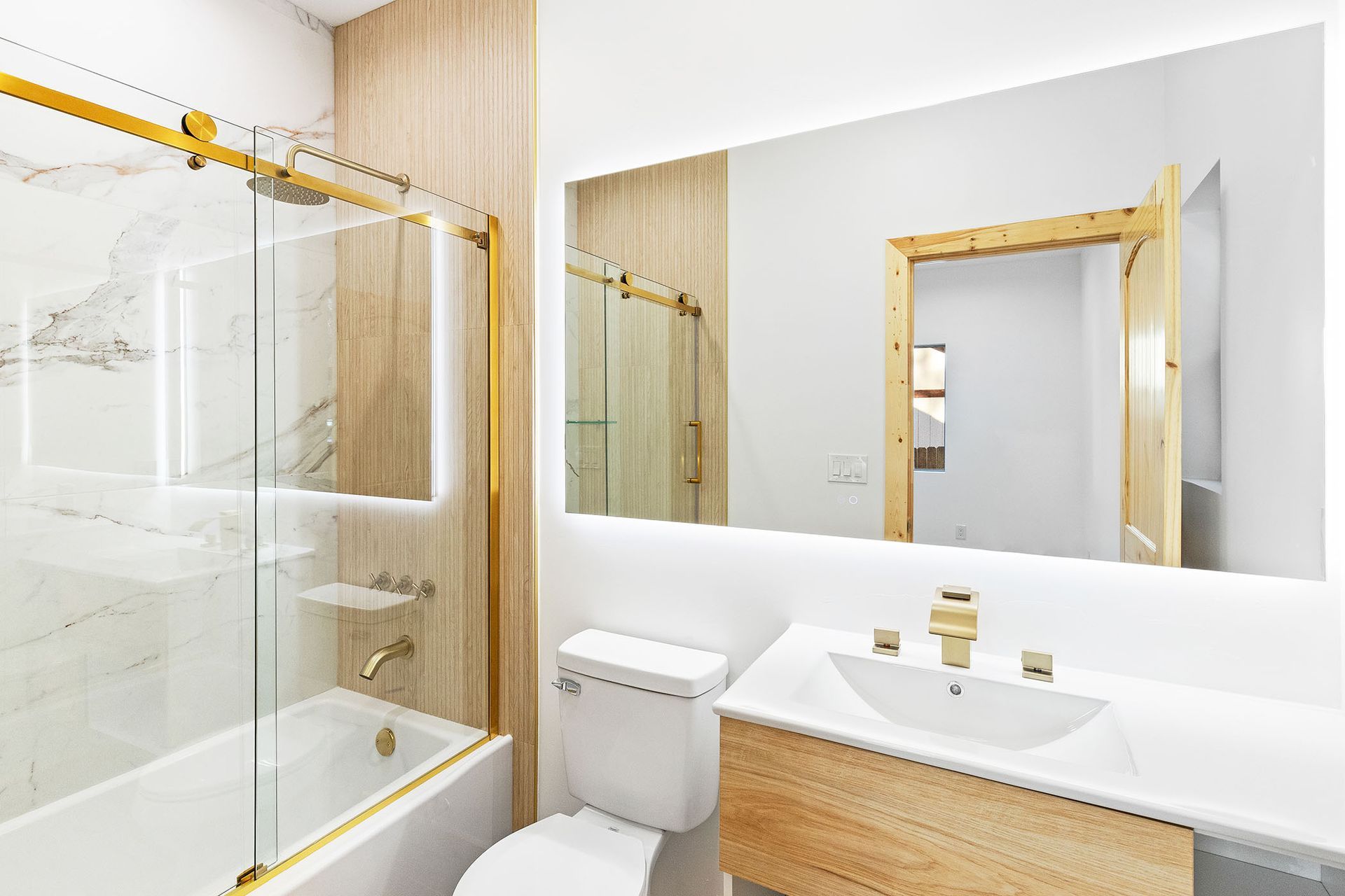 A bathroom with a toilet , sink , tub and mirror.