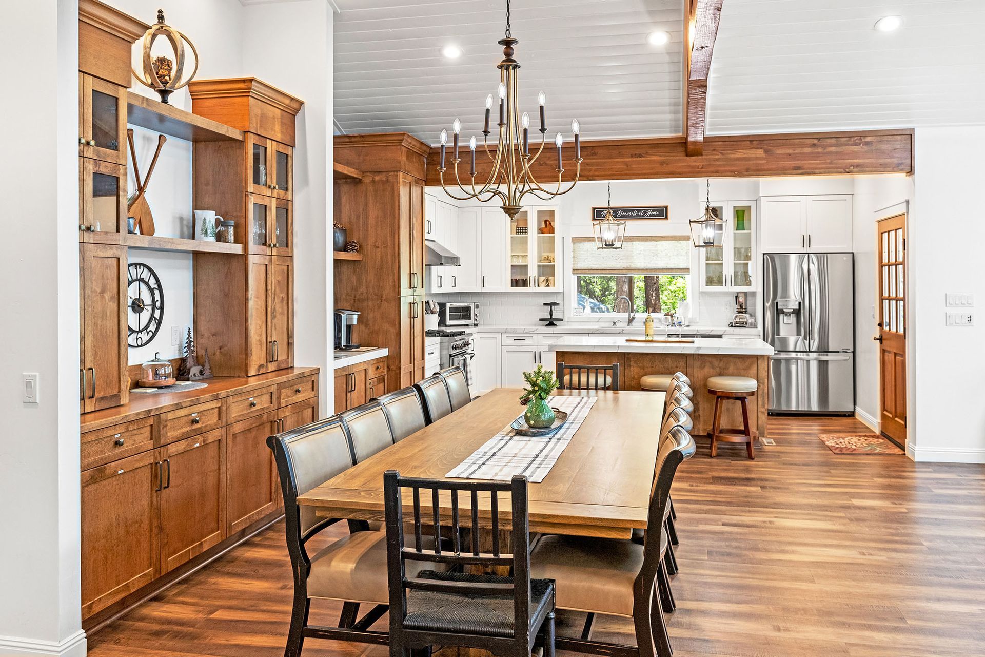 A dining room table and chairs in a kitchen with a chandelier.