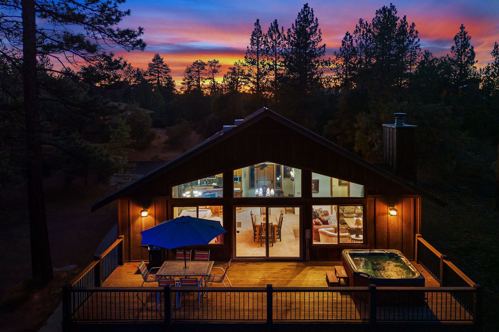An aerial view of a house at night with a hot tub on the deck