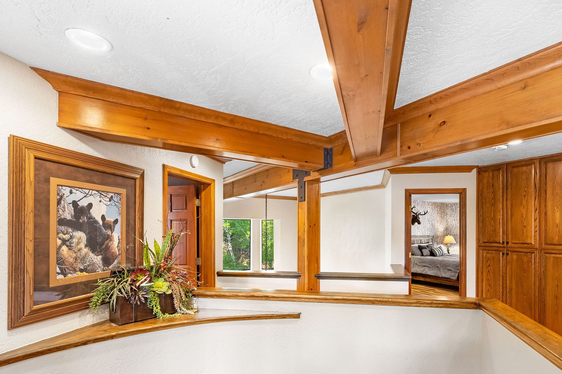A staircase in a house with wooden beams and a painting on the wall.